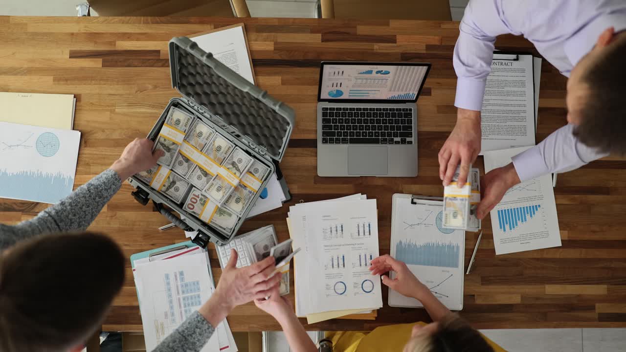 Employees put money in briefcase to promote company in office
