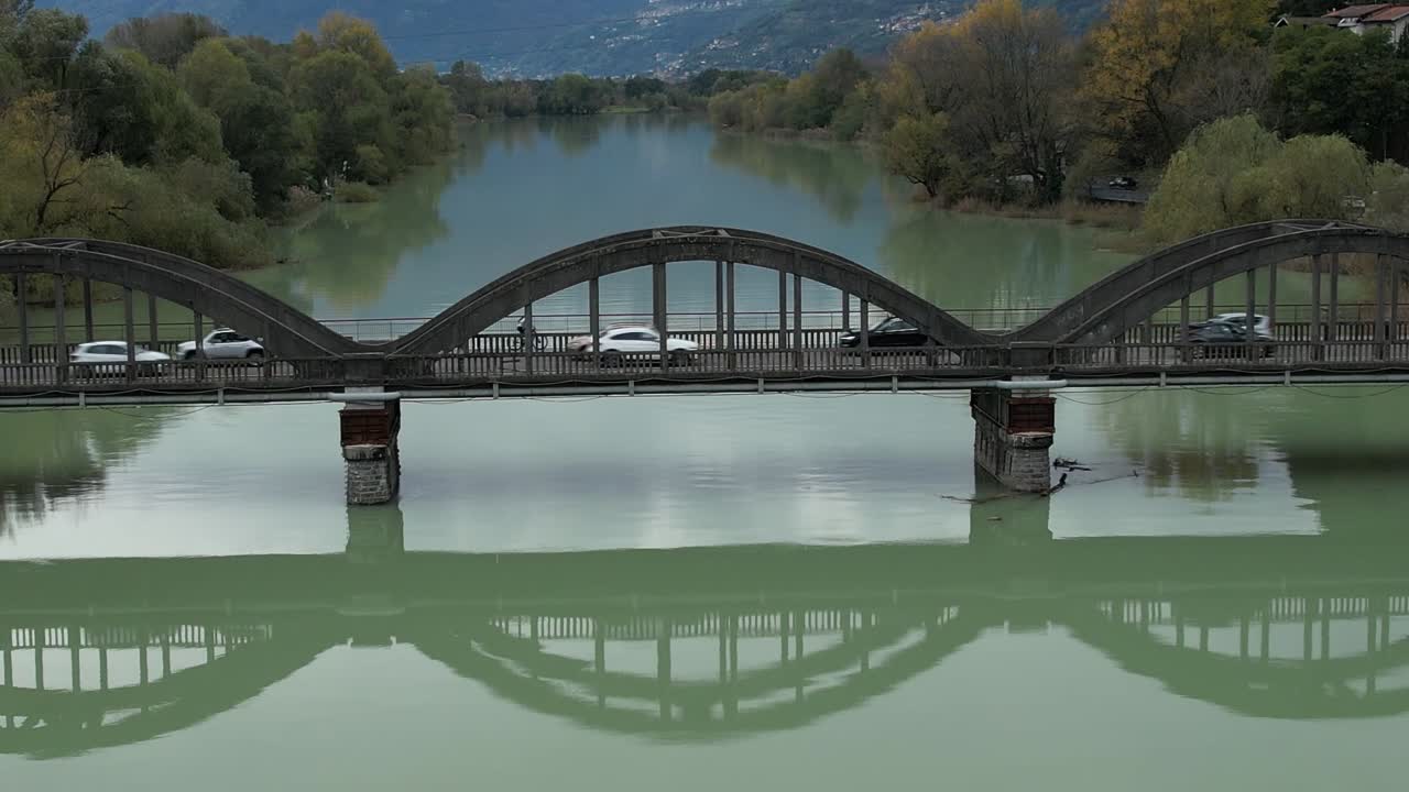 Drone aerial view of a bridge crossing a river in the Italian Alps