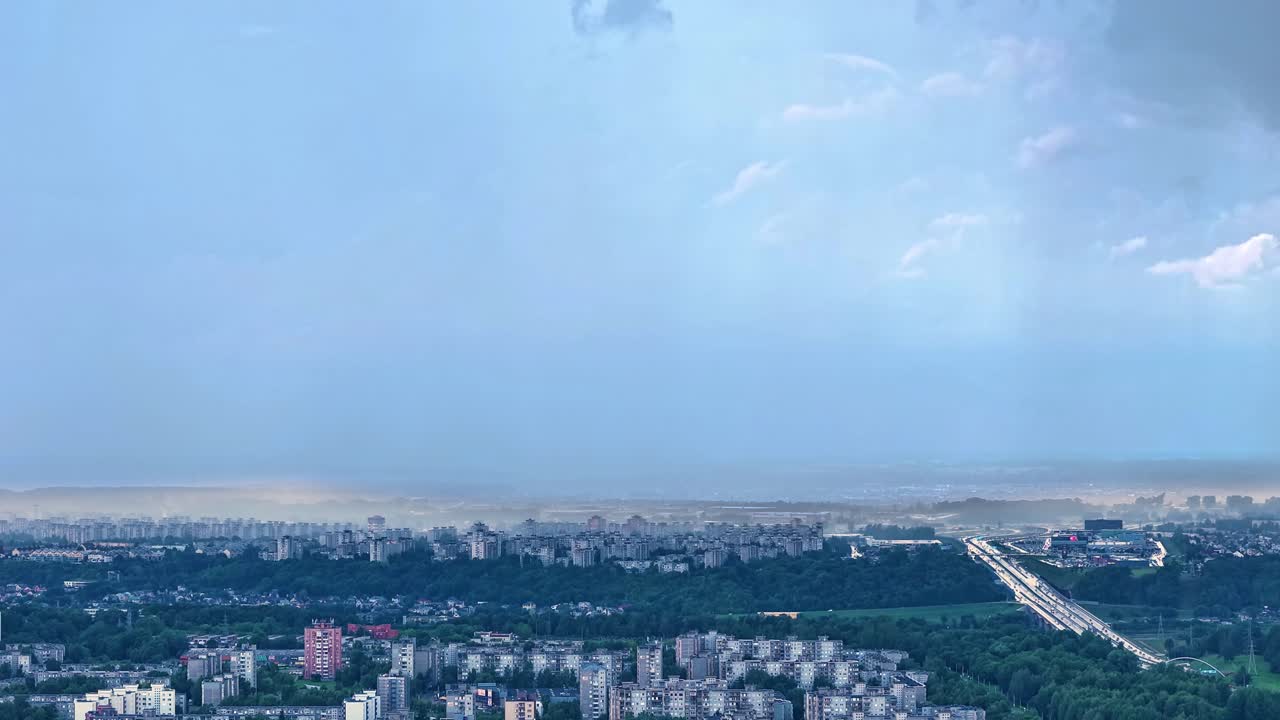 Rainfall and storm clouds flowing above Kaunas city, aerial time lapse view