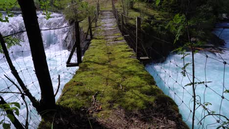 Suspension-bridge-over-the-mountain-river,-Norway.