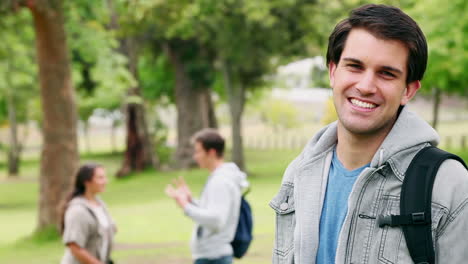 Man-laughing-before-turning-and-looking-at-the-camera-as-he-stands-in-a-park