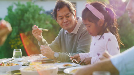 proud grandfather watching his granddaughter eat