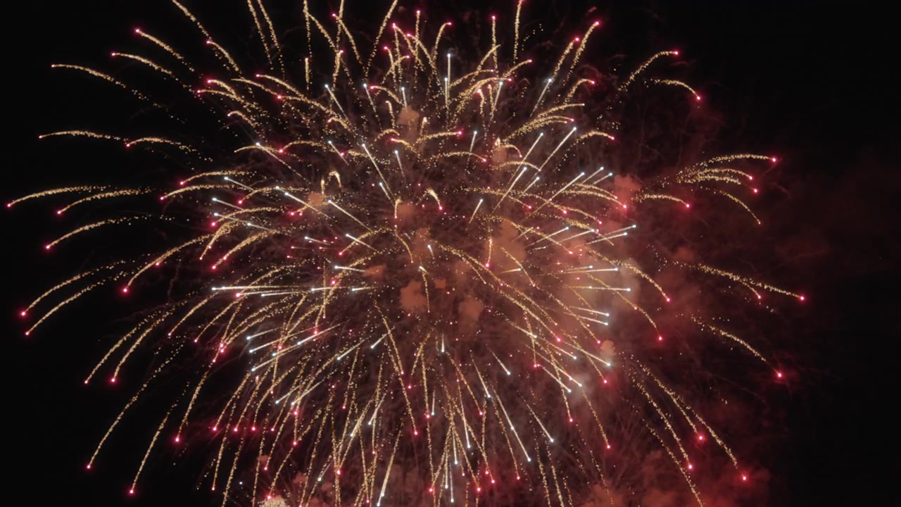 Real fireworks explode in the sky during a celebration. Slow motion