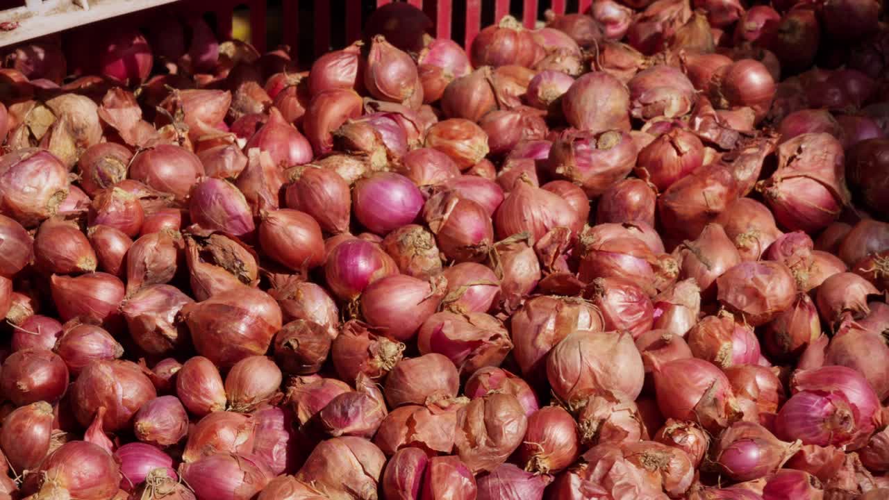 Shallots, dusky pearls, marketplace sales, papery skins of rose and copper