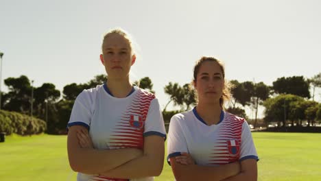 female soccer players standing with arms crossed on soccer field. 4k