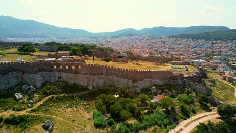 Drone shot going wider revealing the majestic Castle of Mytilene, Greece, on a bright sunny day.
