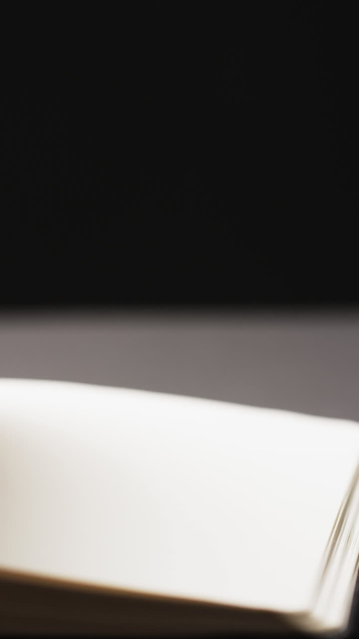 Vertical video of micro of book pages and copy space on grey background
