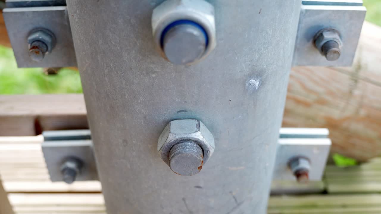 나무 전망대 기둥에 볼트로 고정된 금속 구조 조인트, 근접 촬영