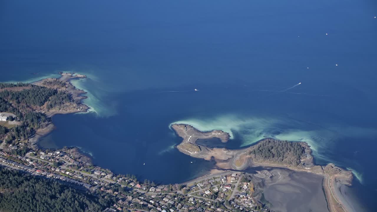 High Aerial View of Coastline with Houses and a Blue Sea