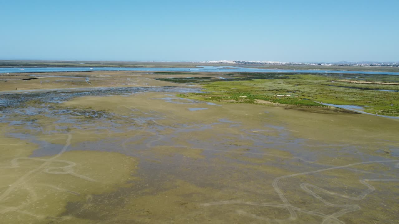 Ria Formosa with riverbed exposed at low tide and Faro in the background on Algarve in Portugal