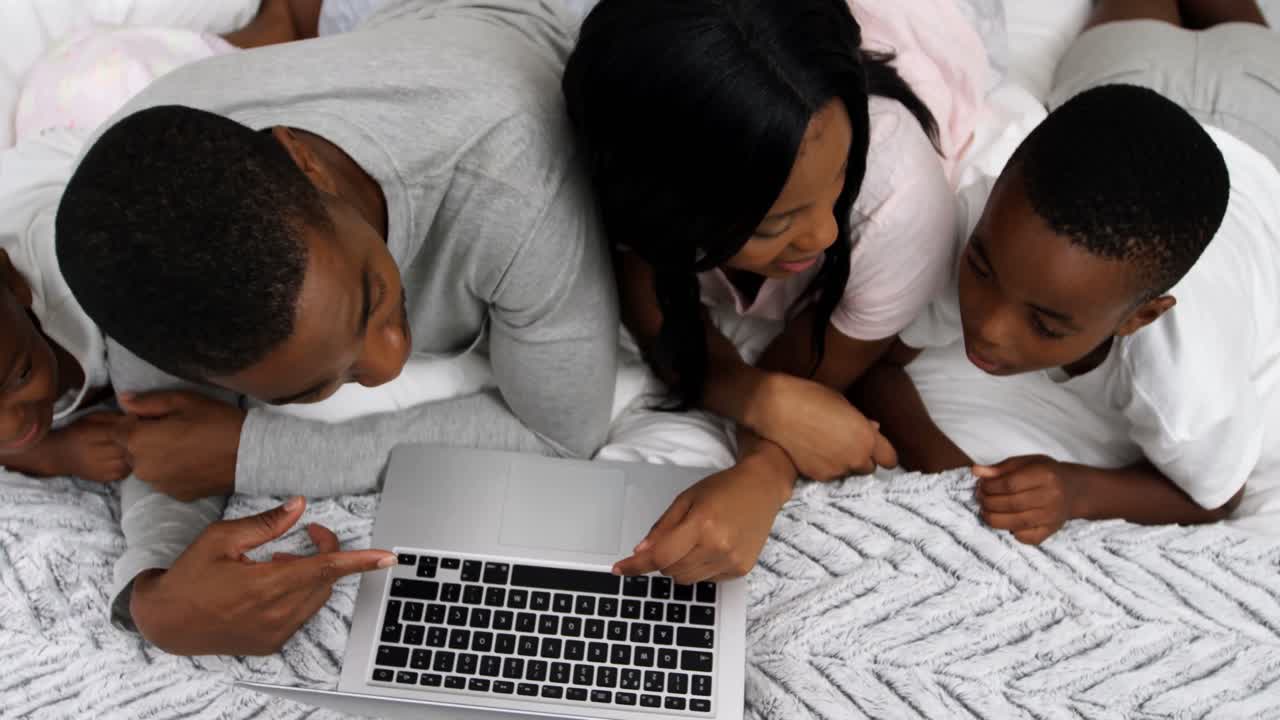 Family using laptop in bedroom 4k