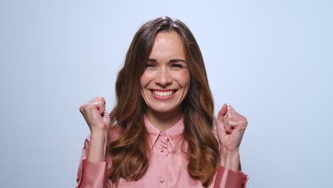 Businesswoman-celebrating-success-in-studio.-Woman-showing-yes-gesture