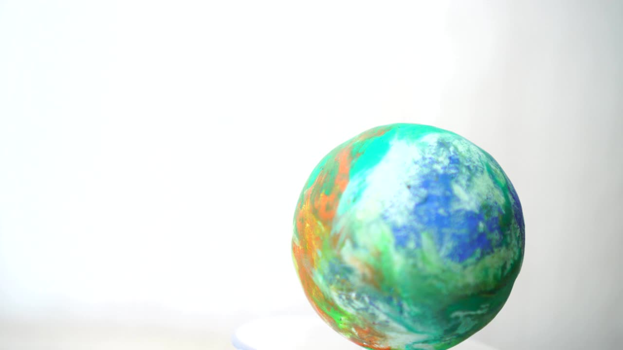 modelos de globo terrestre de arcilla en la creación de un mundo giratorio, giratorio ecología global en fondo gris. bucle creado en 4k