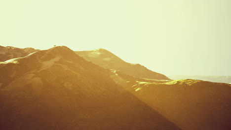 Warm sunlight illuminating gentle hills in a serene landscape at dusk