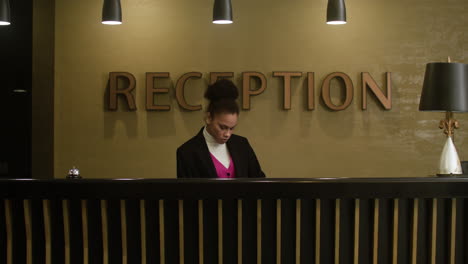 Receptionist-working-at-the-hotel-reception-desk