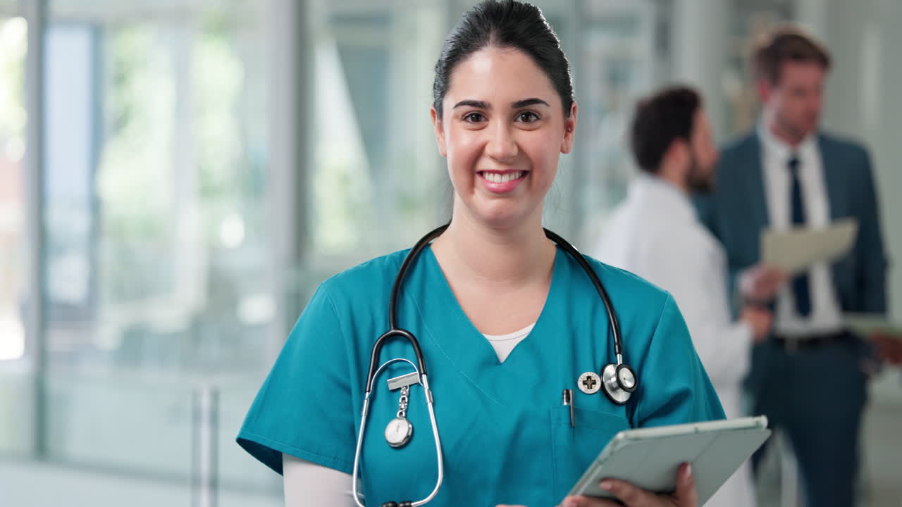 Médica segura sonriendo en el pasillo del hospital con una tablet