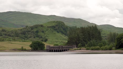 a small dam on a scottish loch surrounded by forest