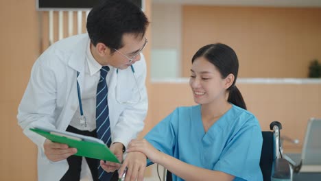 medical professional describes the condition of an asian woman on a wheelchair in hospital