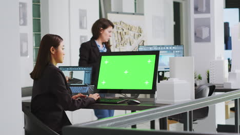 arquitecto utilizando una computadora con pantalla verde en la estación de trabajo