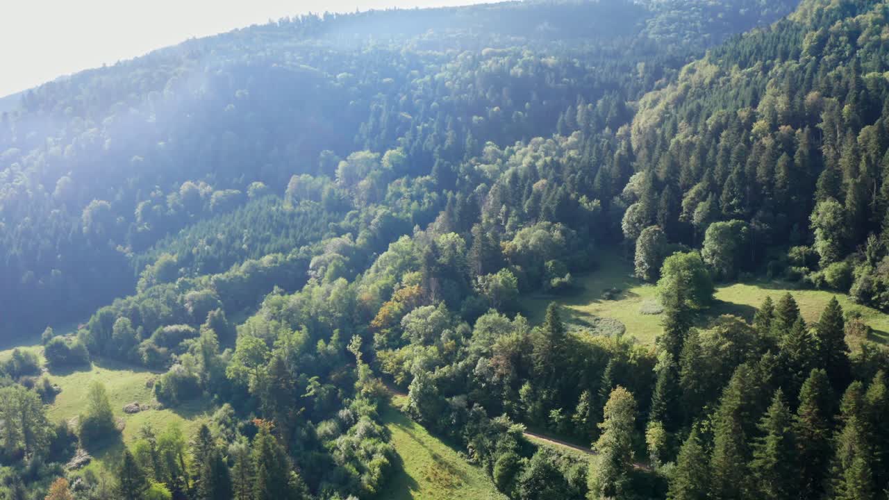 un suave paseo en avión no tripulado por las laderas boscosas de un paisaje montañoso con un curso fluvial