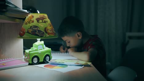 child doing homework at night on his desk