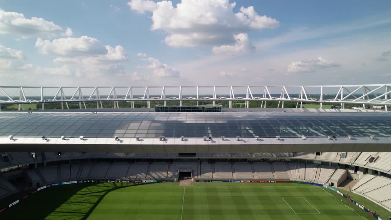 Telecamera in panoramica che rivela la tribuna vuota dello stadio e il campo a strisce, ripreso dal livello superiore, con pannelli solari.