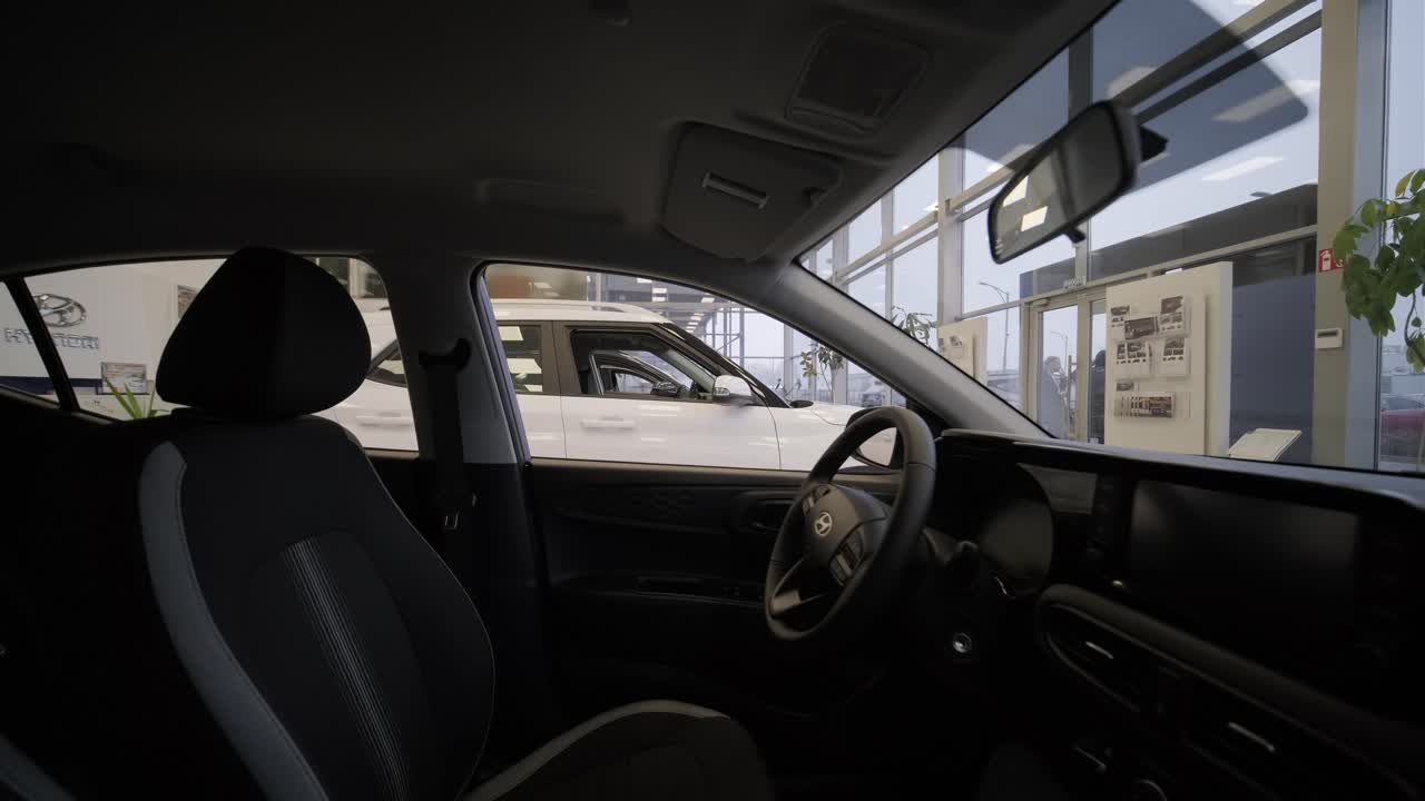Car dealership with row of anonymous new vehicle on sale. Showroom with shiny auto. Automotive