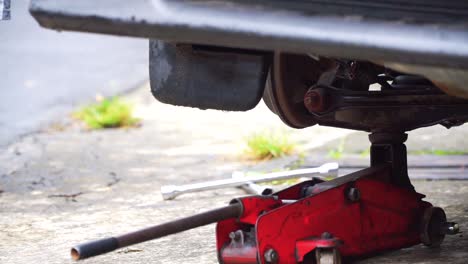 The-jack-is-used-to-lift-the-car-during-the-tire-change-job---Close-up-shot