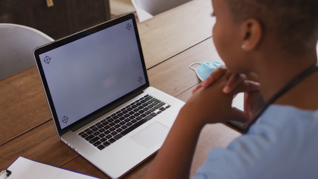 African american female doctor having video call consultation using laptop with copy space