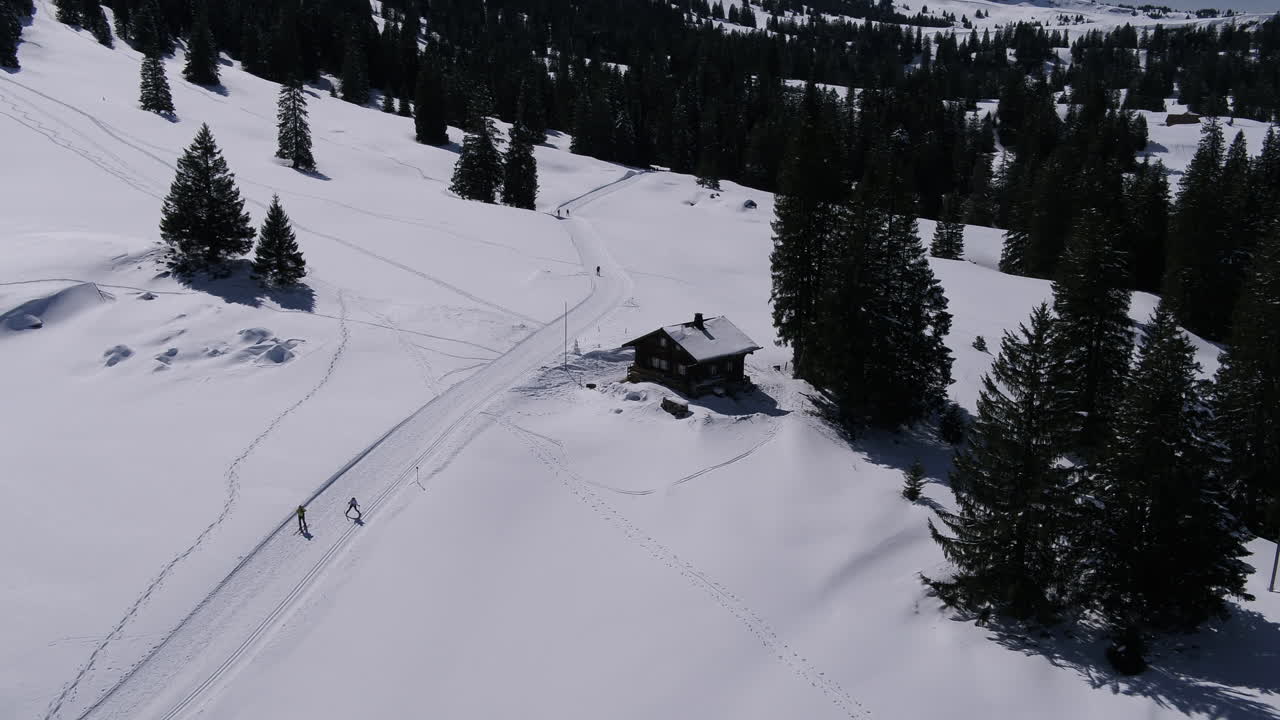Winter in the Mountains. Fly near a Chalet.Some people are skiing