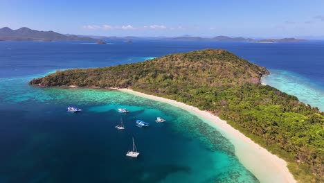 idylic aerial views of ditaytayan island, with boats in calm turquoise waters in philippines