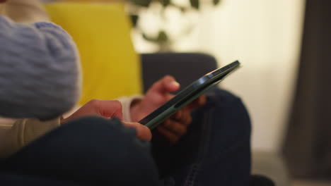 two young boys sitting on sofa at home playing games or streaming onto digital tablet 7