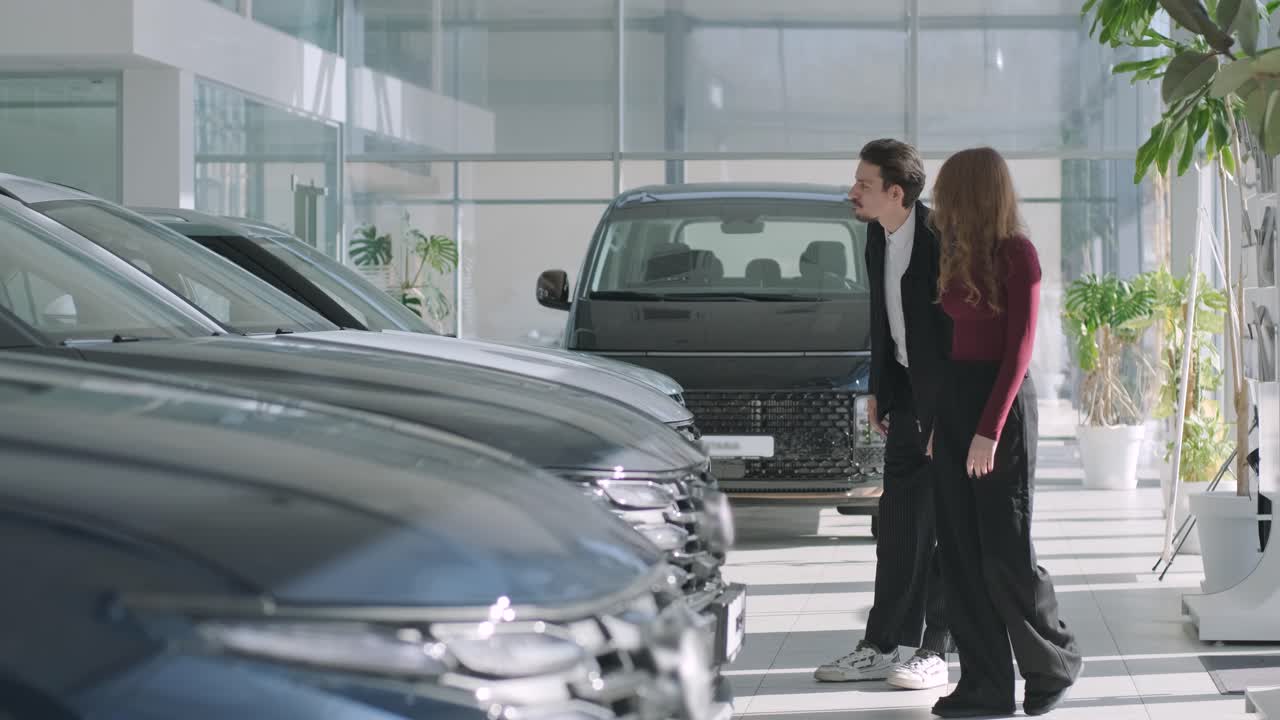 Car dealership showroom with people looking at new cars