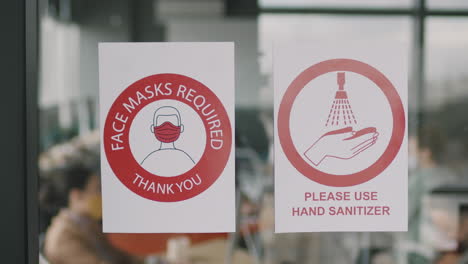 signs on glass wall in office during pandemic