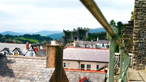 medieval conwy castle battlement railing walls above townhouse settlement rooftops dolly left