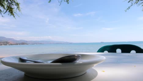 drinking a coffee on the beach looking at the ocean and blue sky on a tropical island in timor leste, south east asia