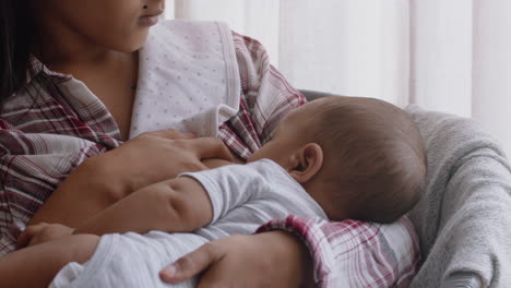 young mother breastfeeding baby at home nursing infant enjoying motherhood