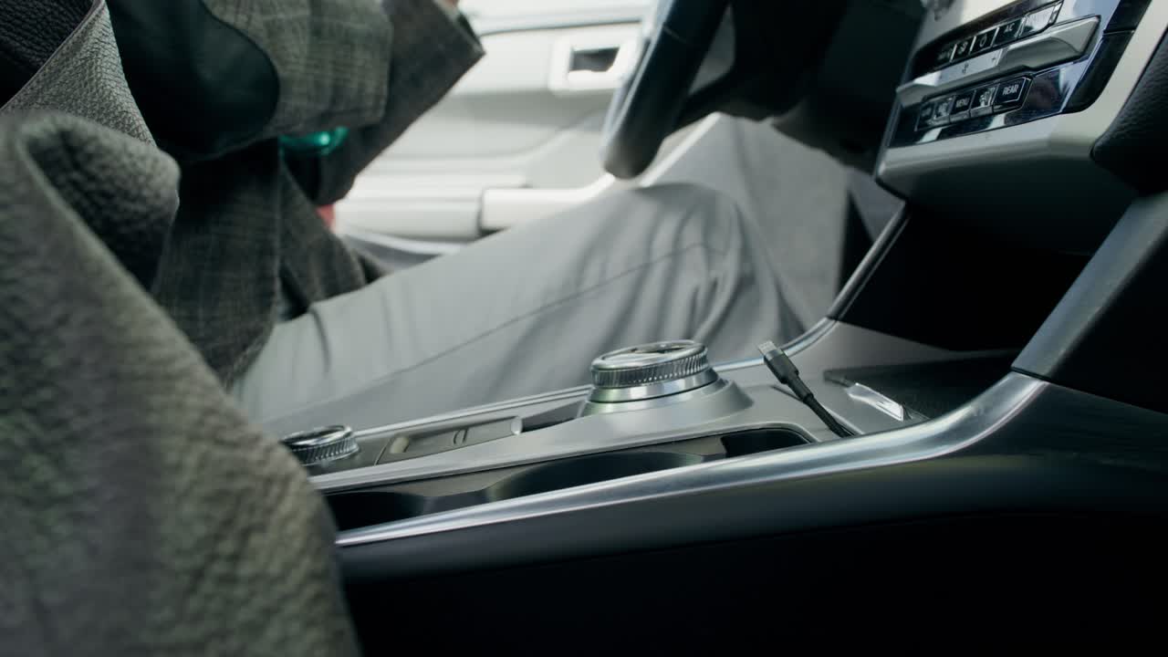 컵 홀더에 물 병을 넣은 차를 운전하는 사람