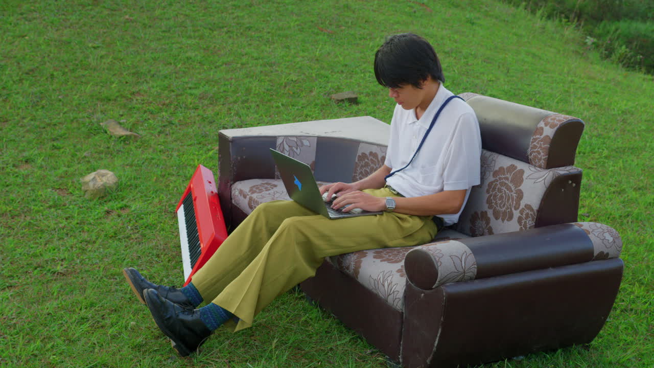 Man Composing Music Outdoors on Laptop