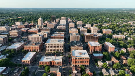 aerial view of a city with numerous buildings surrounded by green trees