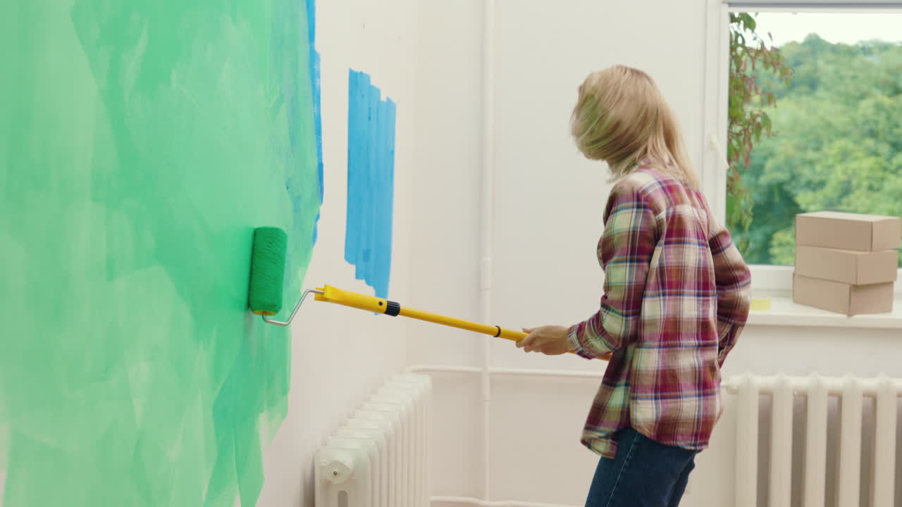 Woman Dancing While Painting a Wall