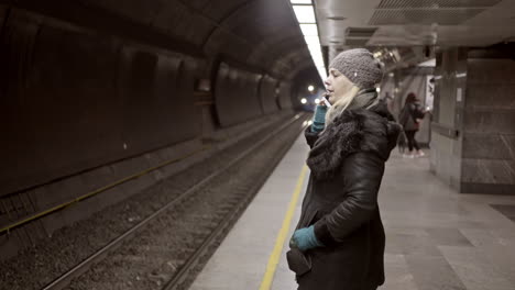 person waiting for a train on a dark subway platform