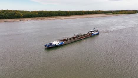 aerial shot of a dredger that glides through a big river, reshaping the landscape