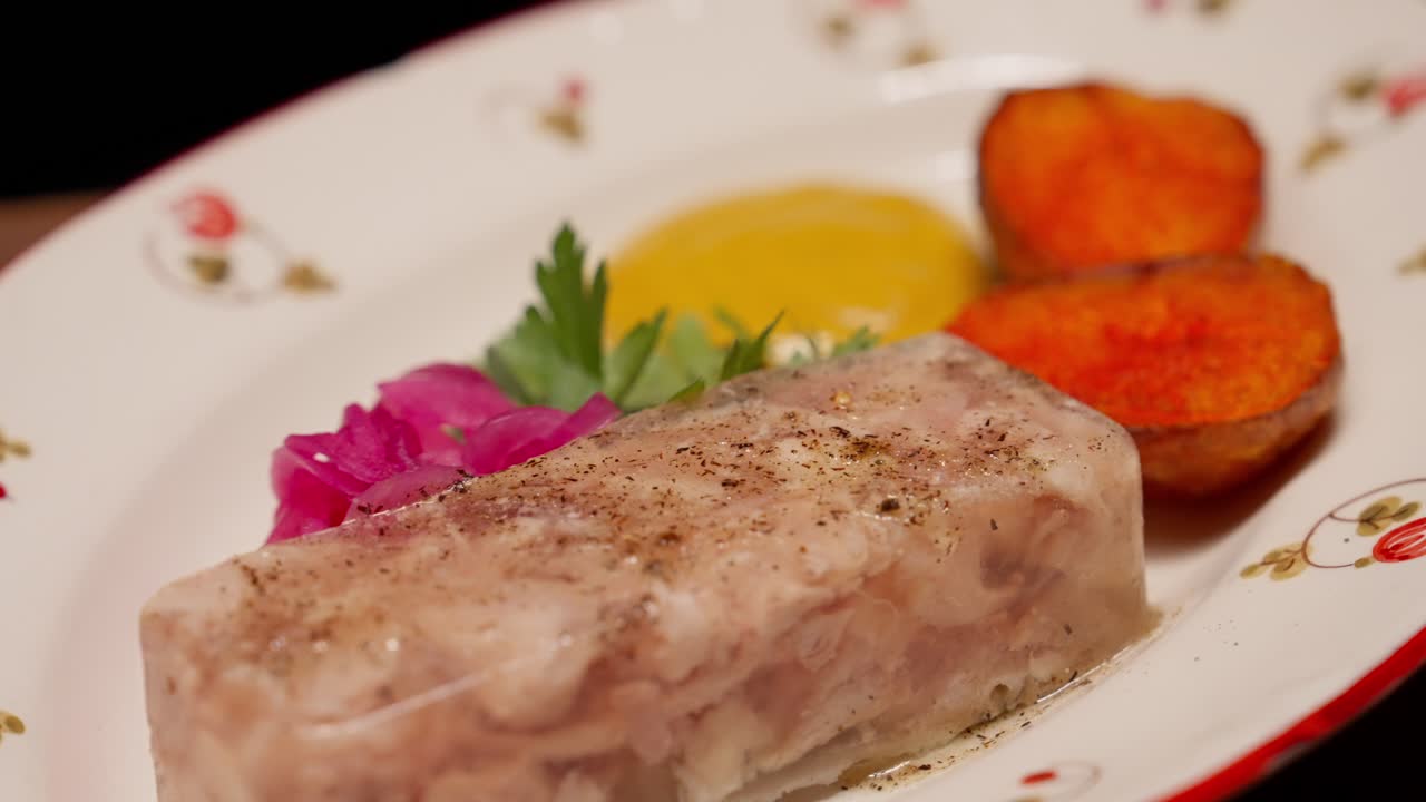 Piatto tradizionale di aspic di carne con senape e cipolline sottaceto