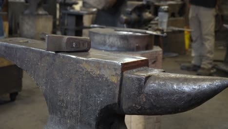 we can see a hammer on an anvil in a blacksmith factory