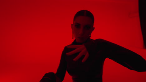 a female dj performs in a studio with red lighting.