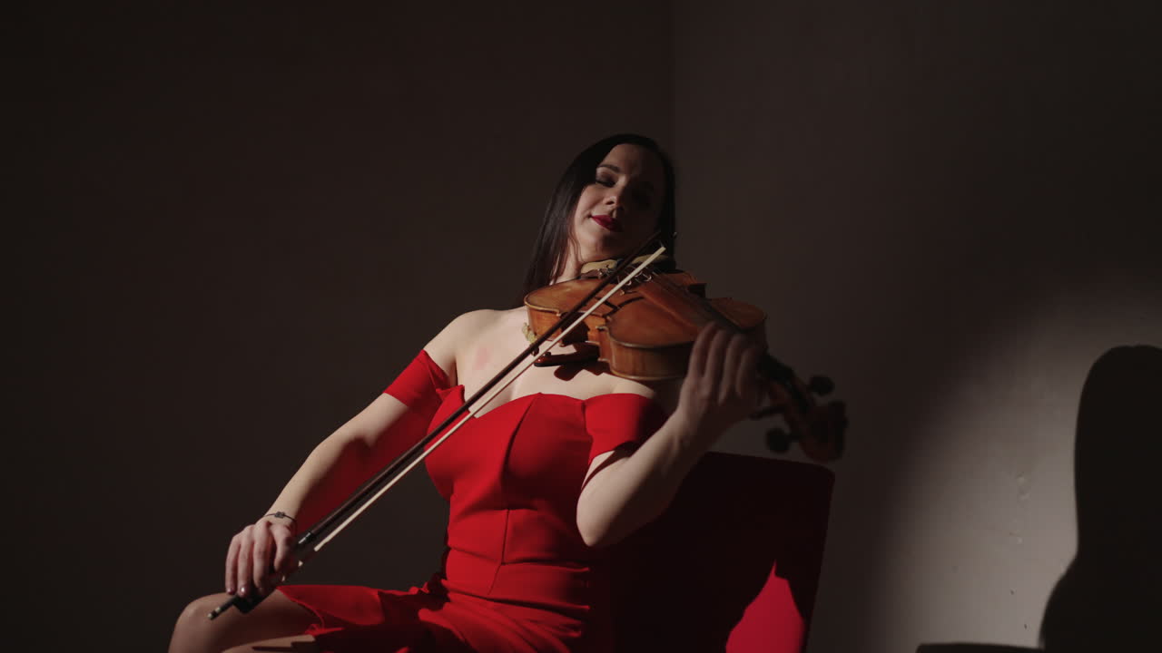 Donna che suona il violino in abito rosso