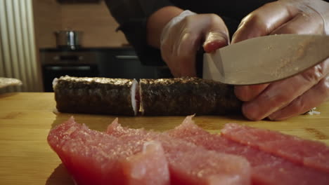 sushi preparation: cutting a maki roll