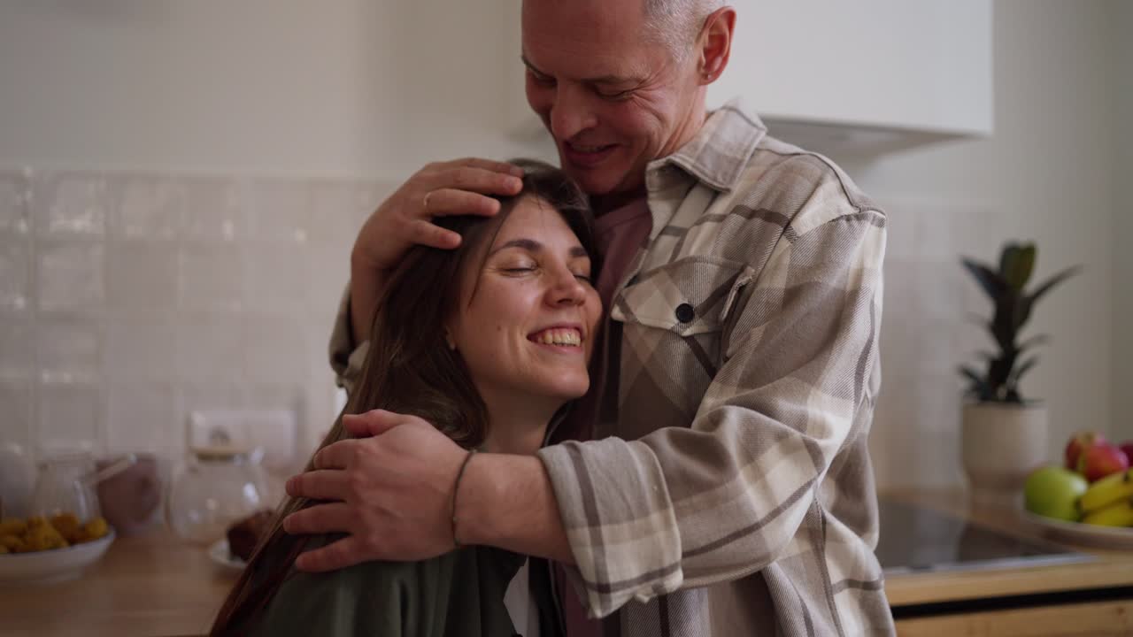 una pareja feliz abrazándose en la cocina.