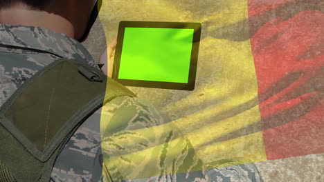 digital composition of waving belgium flag against soldier using digital tablet with copy space